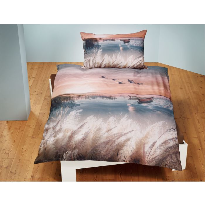 Parure de lit avec coucher de soleil sur un lac calme main product photo